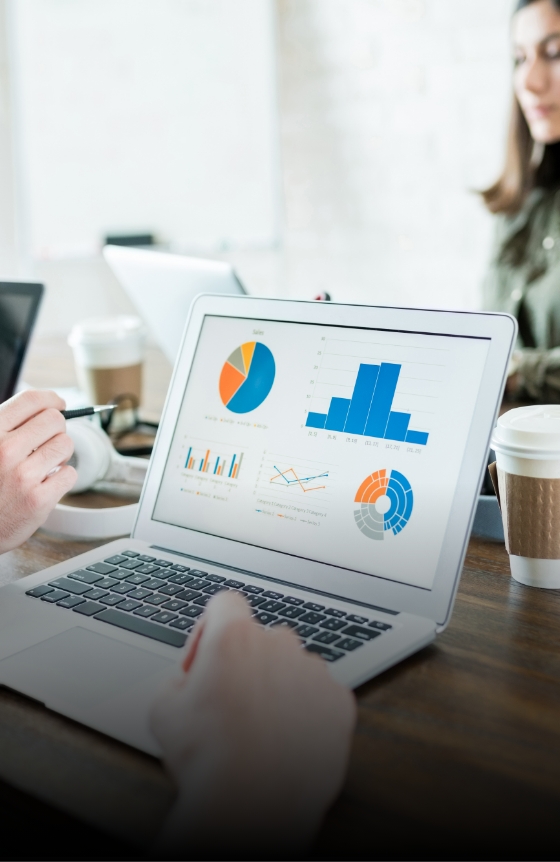 businessman-analyzing-graphs-laptop-while-working-with-colleague-office